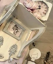 Dekoratives Regal mit Uhr, altem Foto und Blumendekor in romantischem Vintage-Stil.