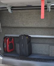 Offener Kofferraum mit zwei Koffern, einem roten und einem schwarzen, in einem Fahrzeug.