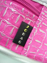 Rosa Tasche mit Silbermuster und einem Etikett mit der Aufschrift "JOBAG".