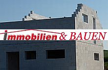 Unvollendeter Rohbau aus Beton mit „Immobilien & Bauen“-Logo über dem Bild.