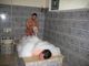 Ein Mann erhält eine Schaummassage in einem Hamam, umgeben von dekorativen Fliesen.