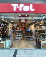 Tienda T-fal con aparatos de cocina en exhibición, vista desde la entrada de cristal.