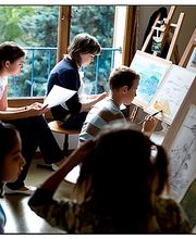 Jugendliche im Kunstunterricht, konzentrieren sich auf das Zeichnen und Malen an Staffeleien.