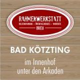 Rotes ovales Logo der "Rahmenwerkstatt" in Bad Kötzting, Text auf Holzoptik-Hintergrund.