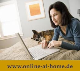 Frau arbeitet am Laptop auf dem Bett, daneben ein Hund. Website-Adresse unten: www.online-at-home.de