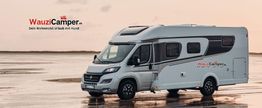 Wohnmobil von WauziCamper steht auf nasser Fläche, Schriftzug: "Dein Urlaub mit Hund".
