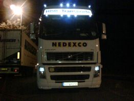 LKW mit der Aufschrift "NEDEXCO" und "HDR Transporte" beleuchtet bei Nacht.