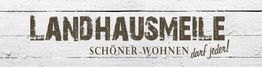 Alt-Text: "Landhausmeile-Logo auf weißem Holz. Text: Schöner Wohnen darf jeder!"