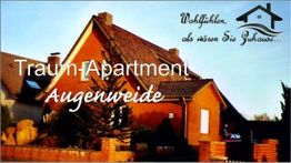 Backstein-Haus mit Schriftzug: "Traum-Apartment Augenweide. Wohlfühlen wie zuhause" oben rechts.