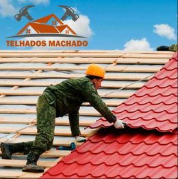 Trabalhador instalando telhas vermelhas em um telhado. Logo "Telhados Machado" ao fundo.