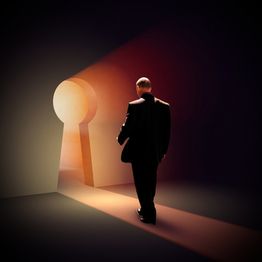 Ein Mann geht durch ein schlüsselförmiges Licht in einem dunklen Raum.