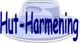 Blauer Schriftzug "Hut-Harmening" auf einem grauen Hut.