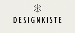 Der Text "DESIGNKISTE" mit einem stilisierten Würfel-Symbol darüber auf hellem Hintergrund.