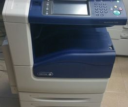 Fotocopiatrice multifunzione con display e pulsanti, posizionata su un pavimento beige.
