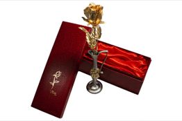 Goldene Rose in Vase, präsentiert in roter Geschenkbox mit Satinfutter.
