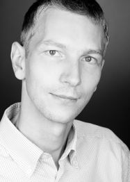 Porträt eines Mannes in Schwarz-Weiß mit kurzem Haar und Hemd.