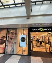 GrandOptical-winkel met brillenreclame op ramen en glazen automatische deuren.