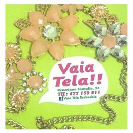Collar de flores con tarjeta de contacto de Vaia Tela sobre fondo verde.