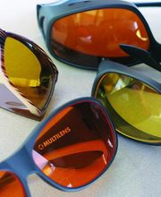 Varias gafas de sol de diferentes colores sobre una superficie lisa.