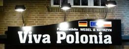 Leuchtschild mit "Viva Polonia", deutschen und polnischen Flaggen, Städtenamen Wesel & Kętrzyn.