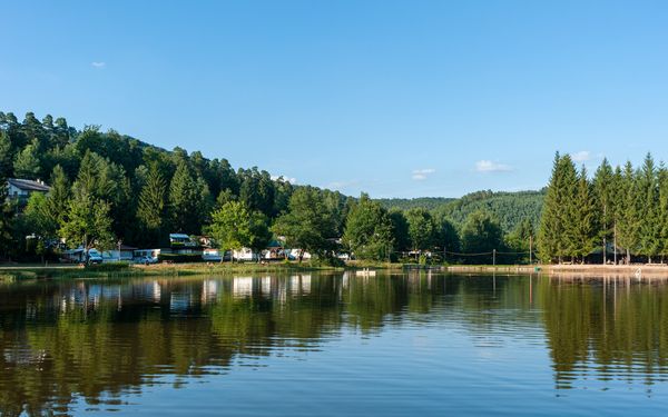 Campingplatz mit Seeblick und blauem Himmel