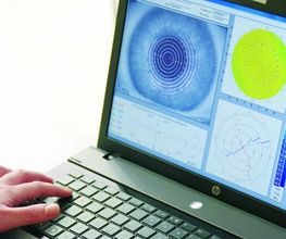 Persona usando una laptop con gráficos de análisis ocular en la pantalla.
