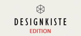 Logo mit einem Würfel und der Aufschrift "DESIGNKISTE EDITION" auf hellem Hintergrund.