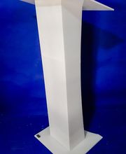 Podio blanco sobre fondo azul, con diseño geométrico y base ancha.