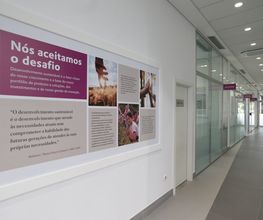 Corredor com quadro na parede sobre desenvolvimento sustentável e inovação em empresa.