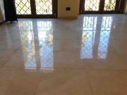 Pavimento lucido in marmo riflette la luce delle finestre con grate.