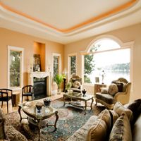 Elegant living room with large window, ornate furniture, and view of a lake.