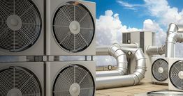Rooftop HVAC units with visible ducts and fans under a blue sky with clouds.