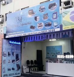 Fachada de loja de informática com letreiro azul e imagens de produtos eletrônicos.