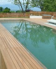 Holzumrandeter Swimmingpool in einem Garten mit Blick auf die Berge im Hintergrund.