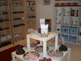 Ein Geschäft mit Regalen voller Kosmetikartikel und einem Tisch mit bunten Schmuckstücken.