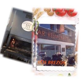 Entrada de "Restaurante Los Brezos" con letrero exterior y horno de leña visible.