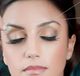 Woman getting eyebrows threaded, eyes closed, with focus on threading technique.