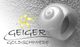 Logo der Geiger Goldschmiede mit einem spiralförmigen Ring und einem gelben Sternmotiv.