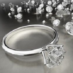 Diamond ring surrounded by scattered loose diamonds on a reflective surface.