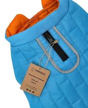 Blaue Hundejacke mit orangefarbenem Innenfutter, Reißverschluss und Etikett mit Details.