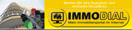 Hochhaus, Ampel und Immobilienwerbung: "Senken Sie Ihre Ausgaben" und "IMMODIAL – Mein Immobilienportal".