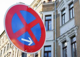 Verkehrsschild für absolut Parkverbot, im Hintergrund historische Gebäude.