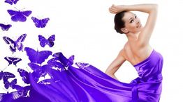 Frau im lila Kleid mit Schmetterlingsmotiven, fließend im Wind.
