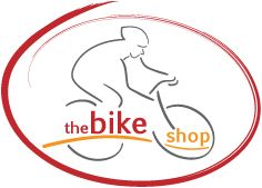 Logo mit stilisiertem Radfahrer und Text "the bike shop" in Rot und Orange, umrahmt von Kurven.