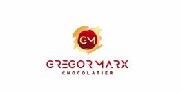 Logo von Gregor Marx Chocolatier mit rotem Kreis und goldenen Akzenten auf weißem Hintergrund.