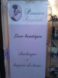 Cartello negozio con testo: "Pensieri Stupendi, Love boutique, Burlesque e lingerie di classe".