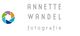 Logo mit Regenbogenkamera und Text "Annette Wandel Fotografie" in grauer Schrift.