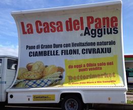 Un camion pubblicitario promuove il pane di "La Casa del Pane di Aggius" con vari tipi di pane.
