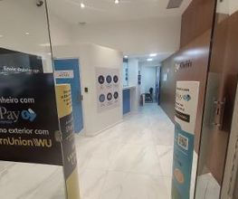Corredor de agência com sinais de transferência de dinheiro da Western Union e PayPay.