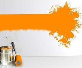 Farbeimer und Rolle vor einer Wand mit orangefarbenem Farbfleck und Streifen.